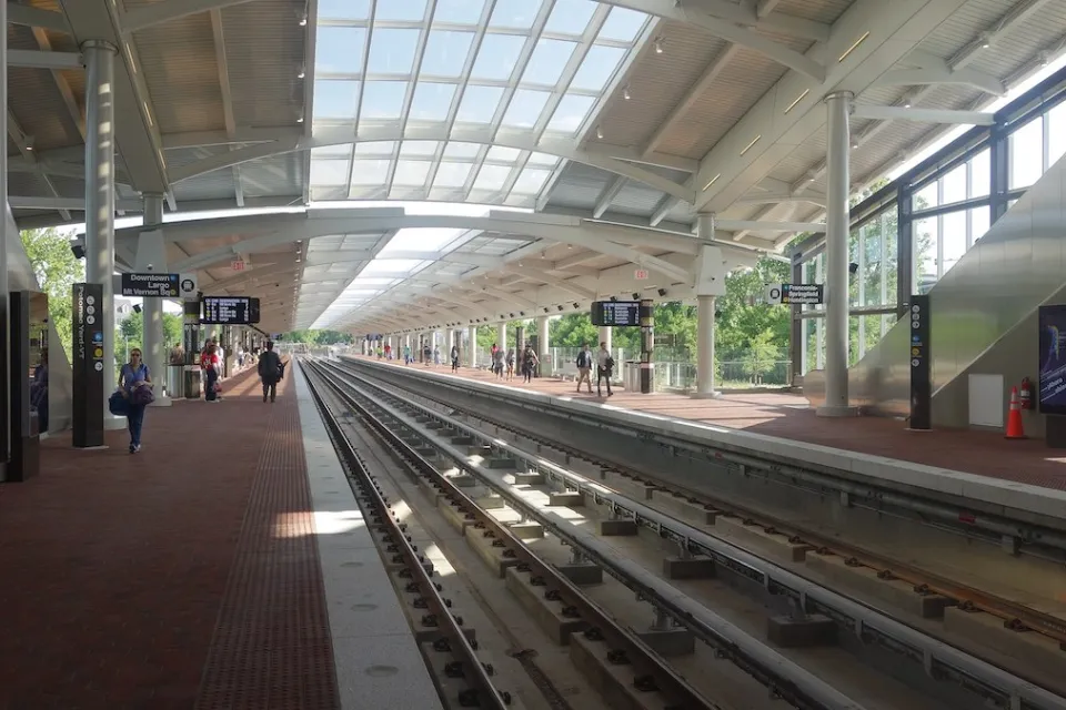 View of Potomac Yard train platform with some passengers waiting.